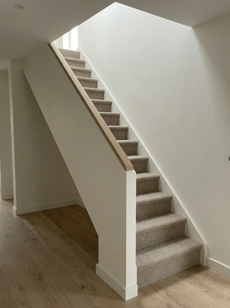 The same flight shown finished, with carpet, a plastered balustrade and a timber capping